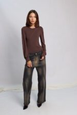 Sandalia modelo Bandhel de gamuza color amarillo maíz. Posee pulsera con hebilla al tobillo, una faja ancha sobre el empeine y taco cuadrado de altura media forrado al tono. Vista de perfil sobre fondo neutro