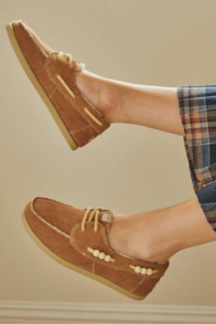 Par de náuticos modelo Masai Stone de la marca Chimmy Churry en color suela, con cordones amarillos e interior forrado en corderito blanco, sobre fondo blanco.