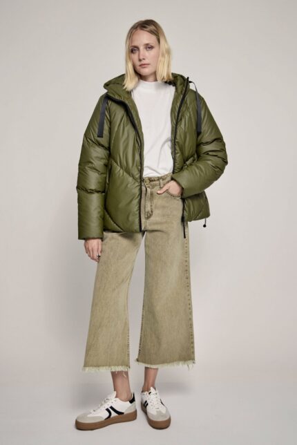 Modelo vistiendo campera puffer Gaiman verde oliva con capucha, remera blanca y pantalón wide leg beige