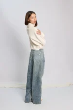 Modelo posando con Jean wide leg Roy con estampa animal print croco y polerón color crudo.
