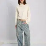 Modelo posando con Jean wide leg Roy con estampa animal print croco y polerón color crudo.
