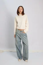 Modelo posando con Jean wide leg Roy con estampa animal print croco y polerón color crudo.