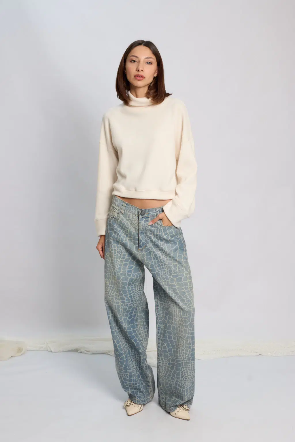 Jean Wide Leg Roy Animal Print Croco Modelo posando con Jean wide leg Roy con estampa animal print croco y polerón color crudo.