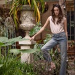 Modelo luciendo el Jean Berkeley recto de tiro alto en tono azul gastado combinado con musculosa rosa de Estancias Wear.