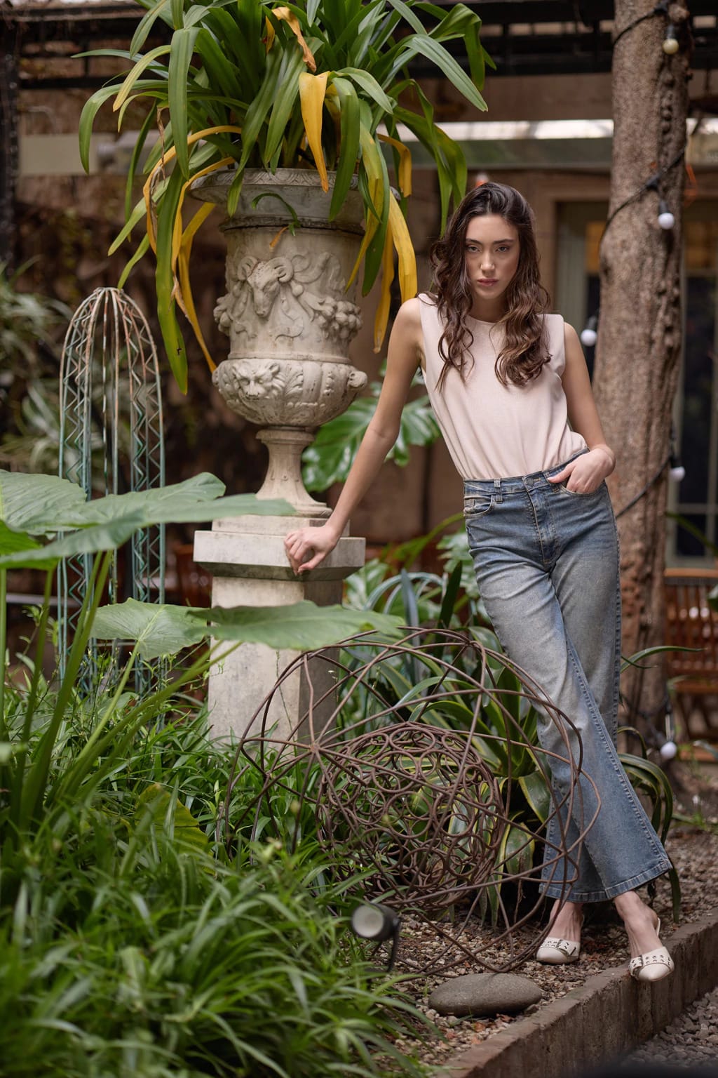 Modelo luciendo el Jean Berkeley recto de tiro alto en tono azul gastado combinado con musculosa rosa de Estancias Wear.