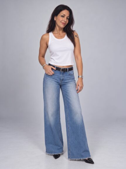 Modelo vistiendo Jean Loto Vanesa Petris wide leg azul con ruedo deshilachado y musculosa blanca
