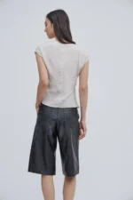 Top Antonina color champagne satinado con escote en V y nudo frontal de Estancias.