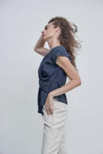 Top Antonina azul noche satinado con escote en V y nudo frontal de Estancias.